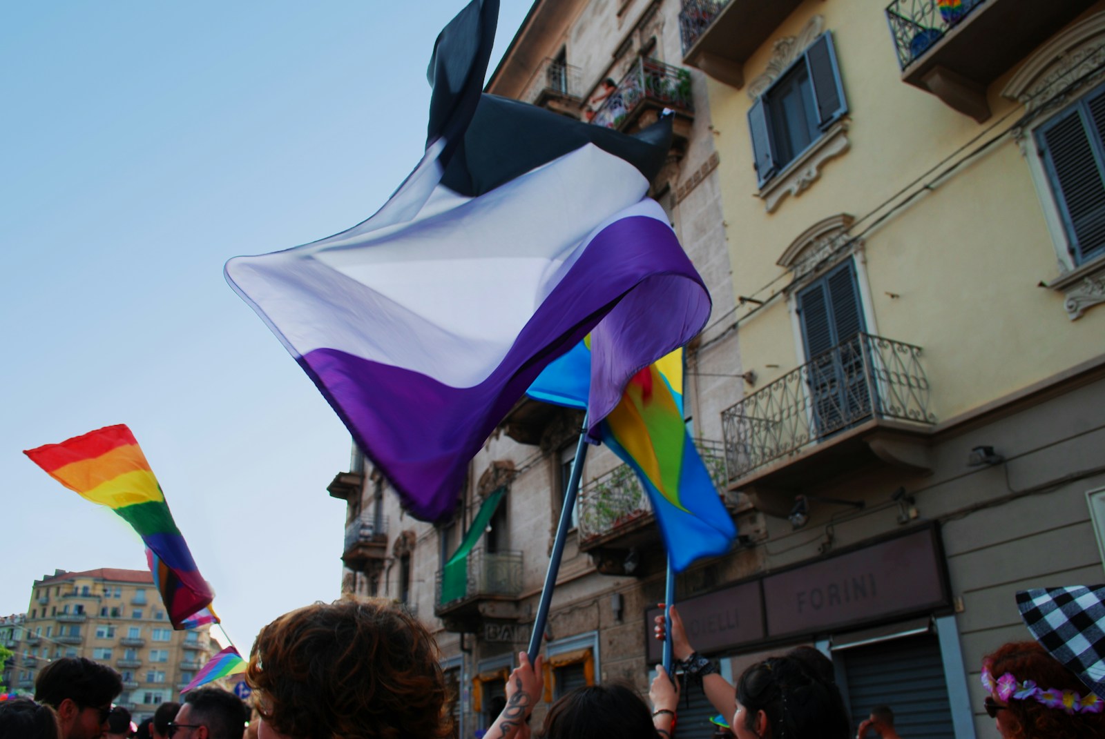 a group of people holding rainbow flags in front of a building